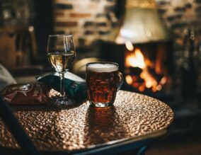 Glass of wine and pint of beer in a pub by the fire