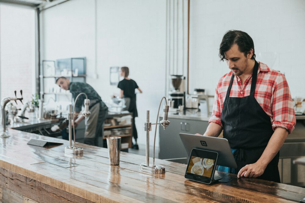 Waiter in cafe looking at a computer