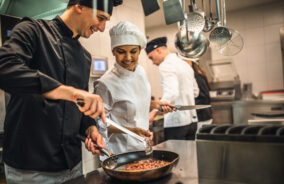 The team of cooks backs in the work in the modern kitchen,