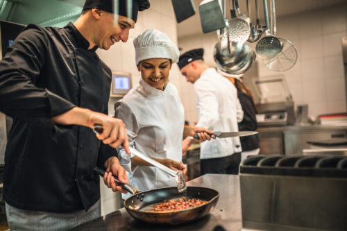 The team of cooks backs in the work in the modern kitchen,