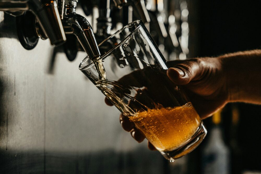 Pint of beer being poured in a pub