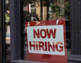 Now hiring sign in a shop window